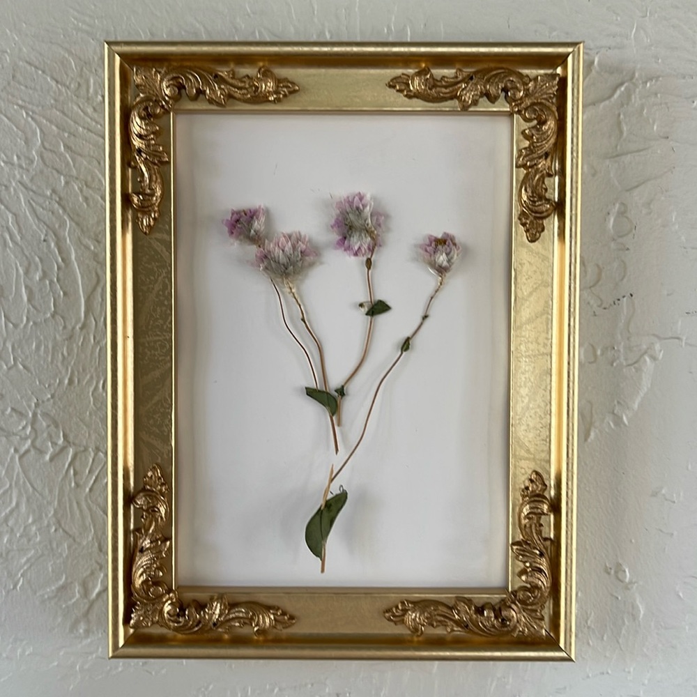 Dried pressed floral wall art with hues of pink, green and gold